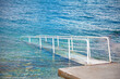 White metal railing on the pier in the sea. Summer sea background