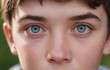 © Andrey - Closeup of a boys face with blue iris, smile, and hair