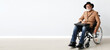Senior man in wheelchair near light wall