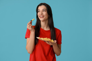 Wall Mural - Beautiful young woman with french fries on blue background