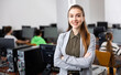 © JackF - Waist-up portrait of positive young woman teacher standing in computer class.