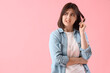 Beautiful young stressed woman on pink background. Stress Awareness Month