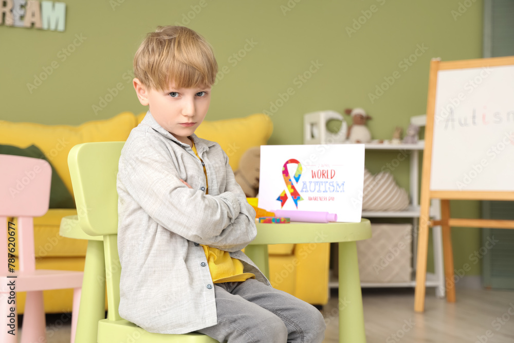 Upset little boy sitting at psychologist's office. World Autism Awareness Day