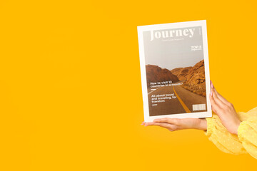 Poster - Female hands with magazine on yellow background