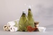 Bottles of cleaning product, brushes, rags and baking soda on light background