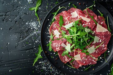 Wall Mural - Beef carpaccio with arugula parmesan black background top view Room for text
