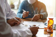 © Marcelo - Male doctor writing and filling a prescription for her patient, medical insurance claim form