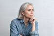 © LAYHONG - Thoughtful mature woman with grey hair looking away while standing against grey background