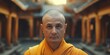 A serene looking bald monk dressed in traditional orange robes, standing in an oriental temple
