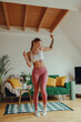 © Daria - Happy woman is gracefully dancing on the hardwood flooring in the living room