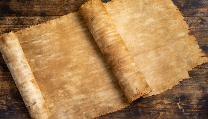 Wall Mural - An aged papyrus manuscript, unrolled, displaying a textured surface with dark spots on a wooden background.