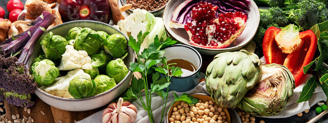 Wall Mural - Vegan food. Pepper, broccoli, cabbage, garlic, mushrooms, pomegranate on a dark background
