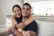 © peopleimages.com - Portrait, home and hug with couple, relax and happiness with love or bonding together in lounge. Face, apartment or man with woman or embrace with romance or relationship with marriage, care or trust