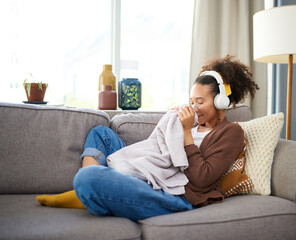 Canvas Print - Woman, clean laundry smell and headphones for music on sofa, comfort and calm with housekeeping. Relax in living room for fresh clothes, scent or fragrance with listening to radio or podcast at home