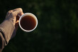 a man holds a mug of coffee, tea and moves
