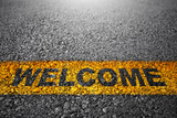 Fototapeta  - Closeup view of asphalt road with welcome text