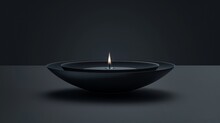   A Black Bowl Holds A Lit Candle, Situated On A Black Surface Against A Backdrop Of A Black Wall