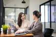 © Wasana - Smiling businesswoman listens attentively during a productive team meeting in a contemporary office setting.