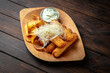  Cheese sticks with potato chips on dark boards background. Menu for a pub