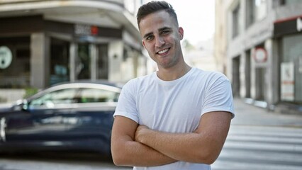 Poster - Handsome hispanic man smiling confidently while standing on a city street, exuding urban appeal and casual style.