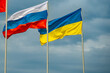 Russian and Ukrainian flags are waving with wind over blue sky. Low angle view. Dispute and conflict concept. Horizontal composition with copy space.