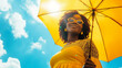 © Keitma - Happy black afro american woman with sunny blue sky holding a yellow umbrella or sunshade to protect her skin from sun light with return of warm days