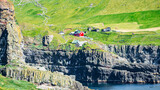 Fototapeta Desenie - Mykines, Faroe Islands. Panoramic view of Mykines island village, bird watching destination for puffins. Traditional houses with turf roofs, cliffs and ocean
