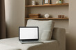 © RooM The Agency - Open laptop computer with a blank screen on a sofa in a stylish living room