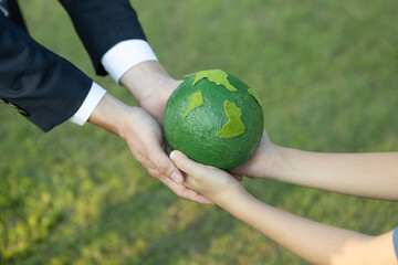 Businessman hand giving Earth globe to little boy as Earth day concept as corporate social responsible to contribute greener environmental protection for sustainable future generation. Gyre