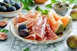Delicious melon ham and figs on white table