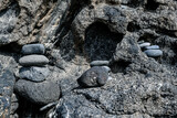 Fototapeta Las - Pretty pile of pebbles between the rocks