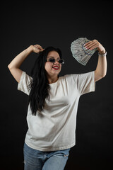 Poster - Caucasian woman holding bunch of us dollar money cash isolated on black