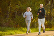 © Studio Romantic - Retirees wife and husband rejoice in active lifestyle. Lovely joyful retirees couple doing sports and jogging together in city park. Senior man and woman in sportswear running on asphalt path.