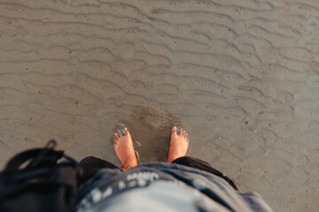 Wall Mural - Feet on the sand at the beach at dusk