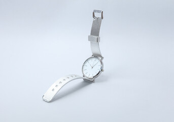 Wall Mural - Silver women's wristwatch floating on a gray background