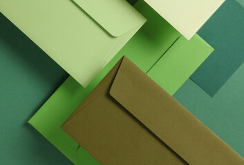 Wall Mural - Set of floating green tones envelopes and cards on green  background. Invitations, corporate identification