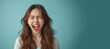 A woman with long hair is screaming and her mouth is open. Concept of anger and frustration. a young woman yelling in simple background, consumer culture critique. strong facial expression