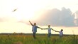 © SUPER FOX - Family playing with flying kite holding hands at sunset grass wheat field outdoor leisure. Happy mother father and son relaxing enjoy freedom lifestyle weekend activity at meadow nature landscape