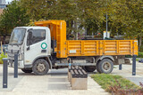 Fototapeta Sawanna - White Truck With Yellow Tipper in City Park Works