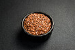 Close-up of flax seeds in a ceramic bowl. Superfood On a dark concrete background.