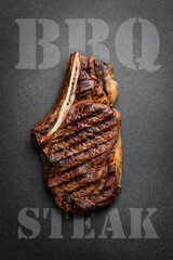 Wall Mural - Steak on the bone. tomahawk steak On a black wooden background. Top view. Free copy space.