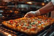 An appetizing image of a chef's hand placing a freshly oven-baked pizza with melted cheese and toppings onto a surface