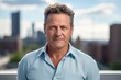 © Markus Schröder - Portrait of a glad man in his 50s wearing a simple cotton shirt on modern cityscape background