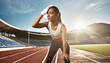 © Bitterheart - female runner tired and wiping sweat on running track at sports stadium