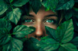 Face of a woman surrounded by green leaves. Piercing eyes and lush foliage