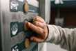 Close up of a hand pressing a button on a self-service coin machine at car wash