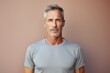 © Markus Schröder - Portrait of a tender man in his 50s wearing a moisture-wicking running shirt in front of minimalist or empty room background