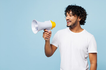 Poster - Young happy Indian man wear white t-shirt casual clothes hold in hand megaphone scream announces discounts sale Hurry up isolated on plain pastel light blue cyan background studio. Lifestyle concept.