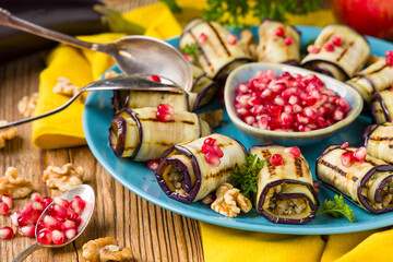 Wall Mural - Delicious appetizer of grilled eggplants. Wrapped in rolls with nut paste. Served with pomegranates.
