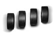 Four black car tires in a row on transparent background